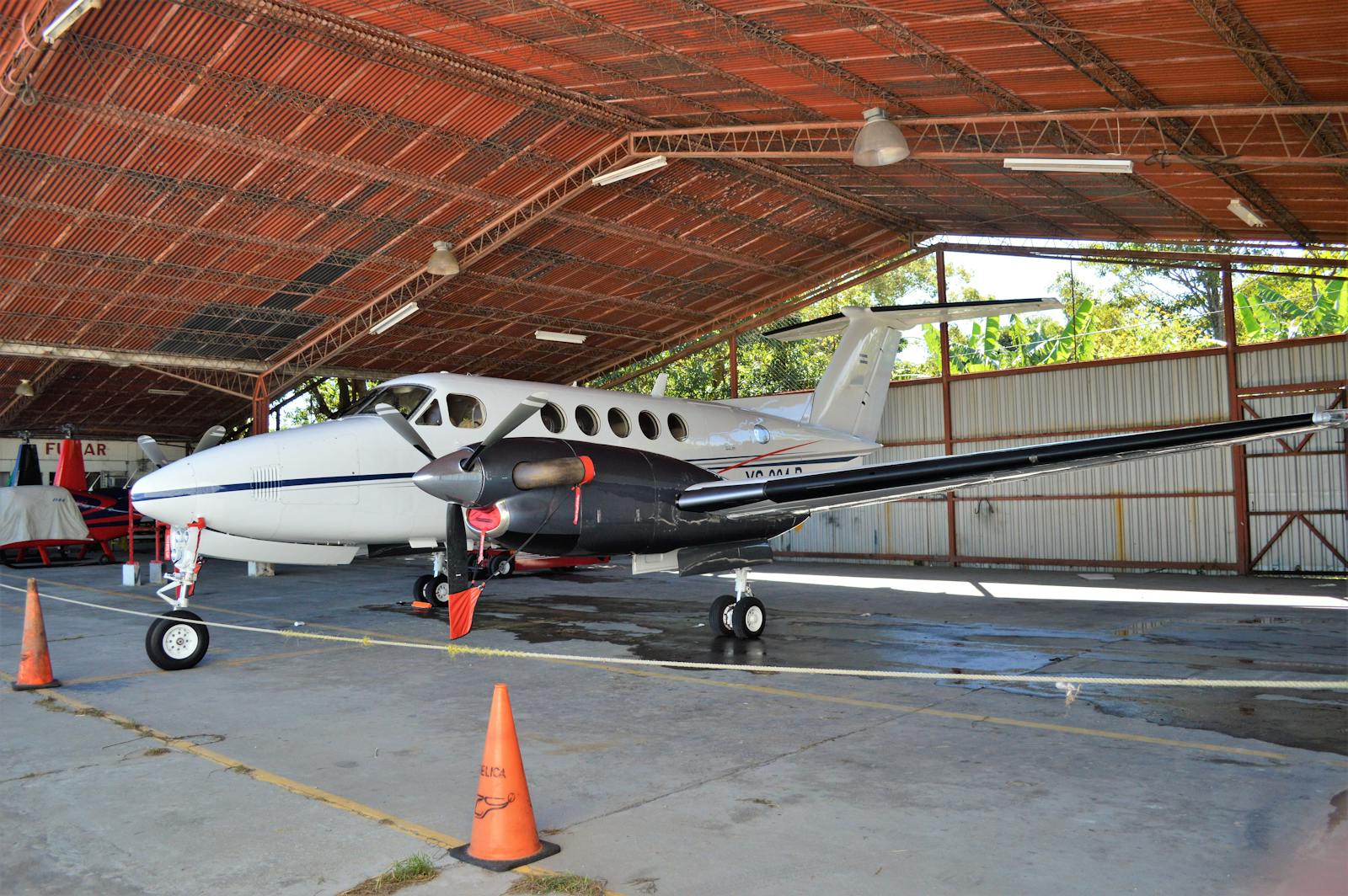 Corporate turboprop aircraft parked inside a spacious hangar.